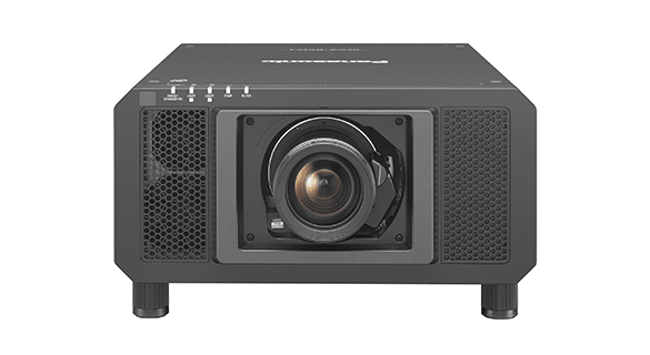Ein schwarzer Panasonic-Projektor mit großer zentraler Linse, nach vorne gerichteten Lüftungsschlitzen und Bedientasten auf der Oberseite. Das Gerät wird von vier kurzen Beinen getragen.